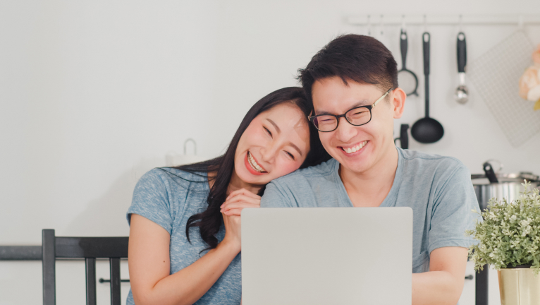 Couple looking at laptop happily